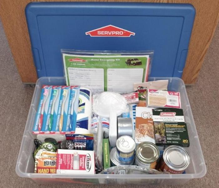 emergency kit containing basic necessities like canned food, water, blankets, flashlights and matches
